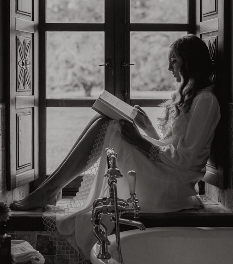 Our rooms Bride reading a book by the Victorian-style bathtub