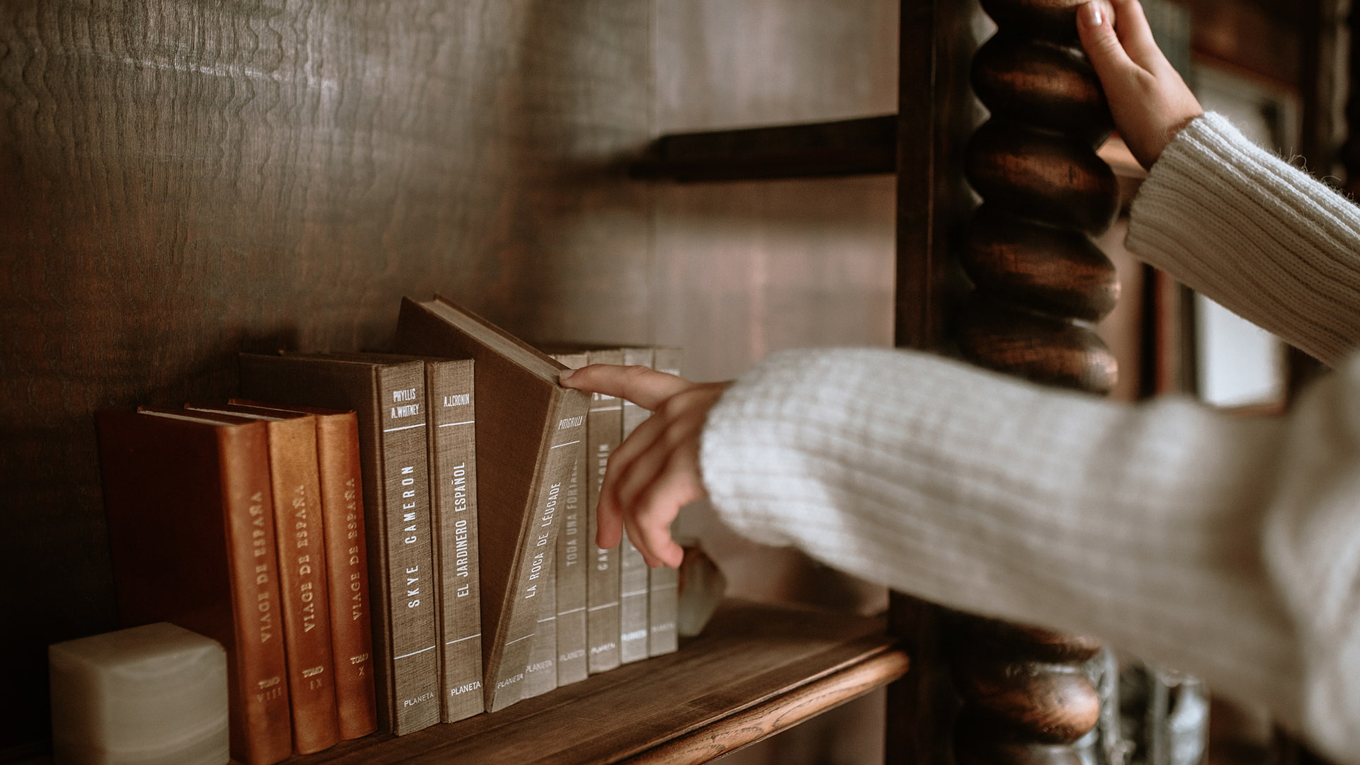 Library Detail of a person's hand, taking a book from the library