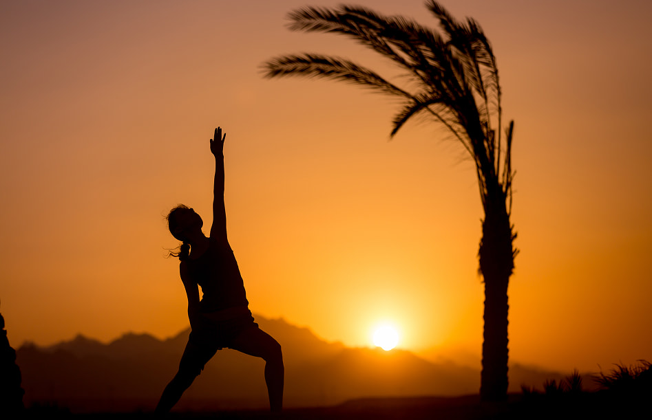 Sunrise & yoga experience Person doing yoga at sunrise