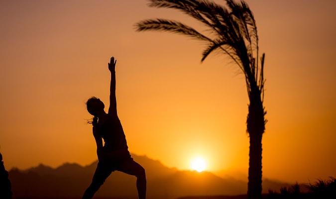 Sunrise & yoga experience Person doing yoga at sunrise