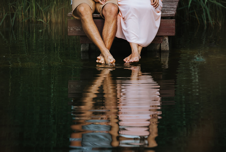 Romantic getaway Legs of a couple sitting on a jetty