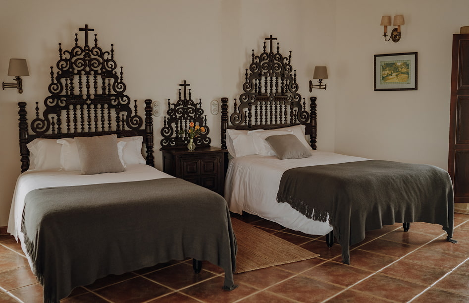 Junior Suite 5 Room with two single beds, with impressive wooden headboards.