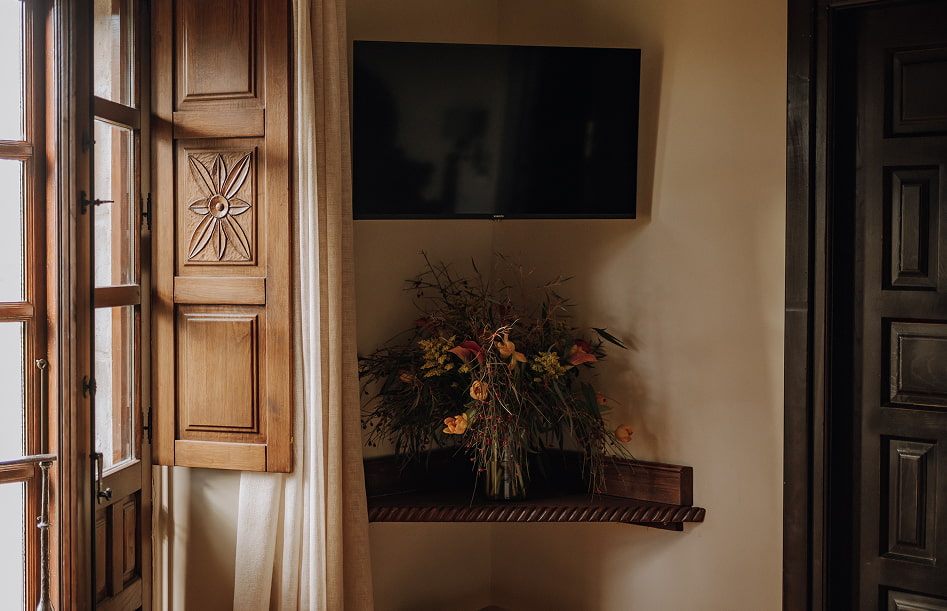 Standard Room 3 Detail of vase with flowers next to the carved wooden window