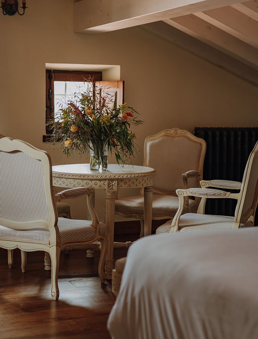 Suite Familiar Detalle de la habiación, donde se ve una mesa redonda con tres butacas